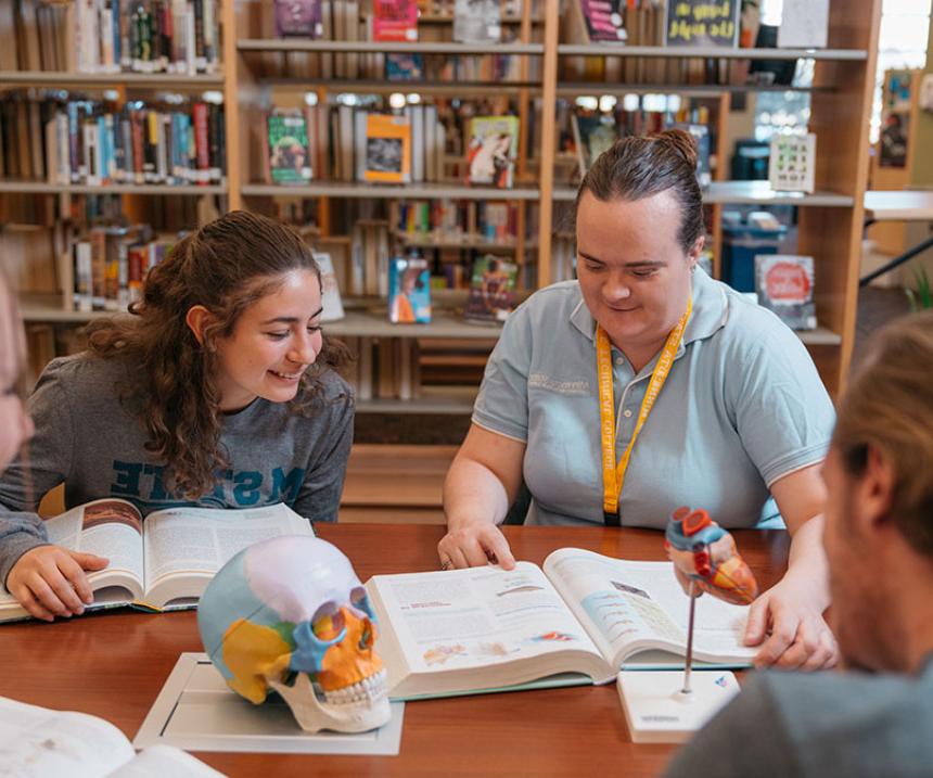  A group of students studies at a table in the library